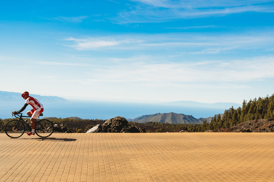 A cyclist riding under a clear blue sky