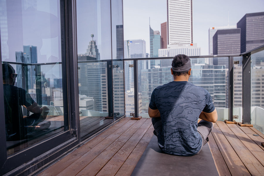 A man sitting calmly on a city balcony